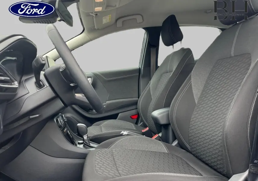 Vue intérieure côté conducteur du Ford Puma 2023, sièges tissu noir Kasbah avec surpiqûres blanches et accoudoir central.