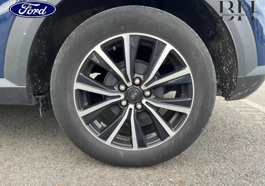 Gros plan sur la roue avant droite du Ford Puma bleu avec jante alliage noire et argentée 17 pouces.