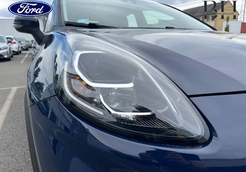 Gros plan sur le phare avant gauche du Ford Puma bleu Abysse 2023, soulignant les détails LED et la carrosserie brillante.