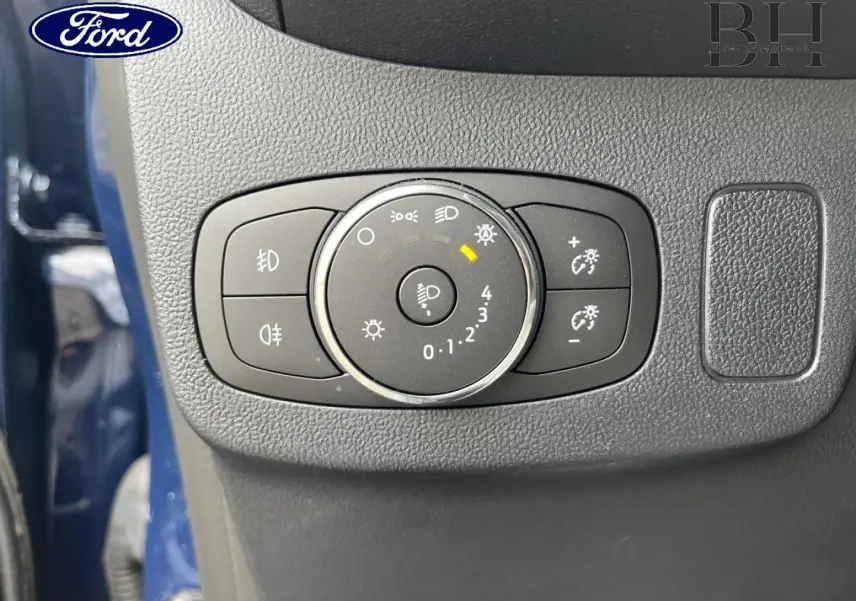 Gros plan sur la molette de réglage des phares du Ford Puma bleu, avec commandes d’éclairage et luminosité.