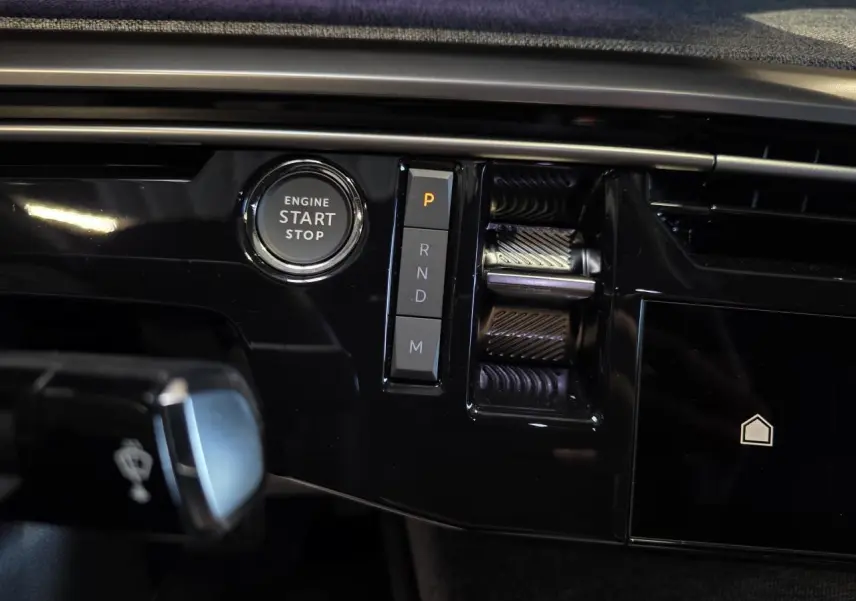 Détail de la console centrale noire brillante du Peugeot 3008 2025 avec bouton start/stop et sélecteur de boîte auto.