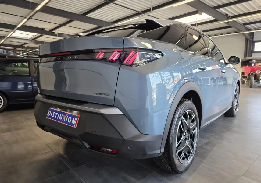 Vue 3/4 arrière droite du Peugeot 3008 hybride bleu clair avec jantes alliage noires et feux arrière LED 3 griffes.