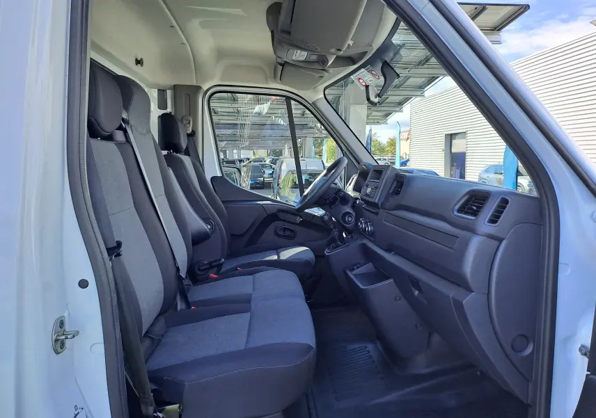 Vue intérieure côté conducteur du Nissan Interstar châssis cabine blanc 2024, montrant les sièges et le tableau de bord.