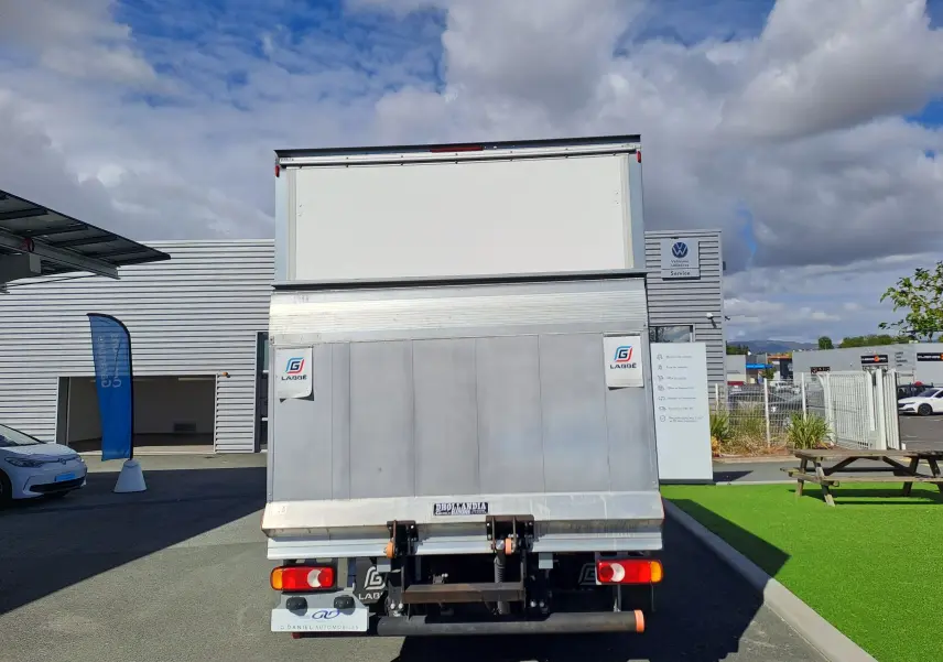 Vue arrière d’un utilitaire blanc Nissan Interstar Chassis Cabine 2024 avec caisse fermée et hayon élévateur.