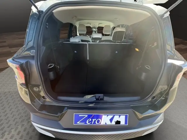 Coffre ouvert vu de l'arrière d'un Citroën C3 Aircross vert, montrant l'espace intérieur et les sièges arrière.