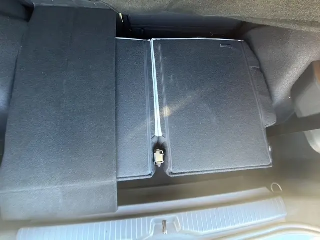 Vue plongeante sur le coffre du Citroën C3 Aircross hybride vert, avec banquette arrière rabattue et plancher plat.