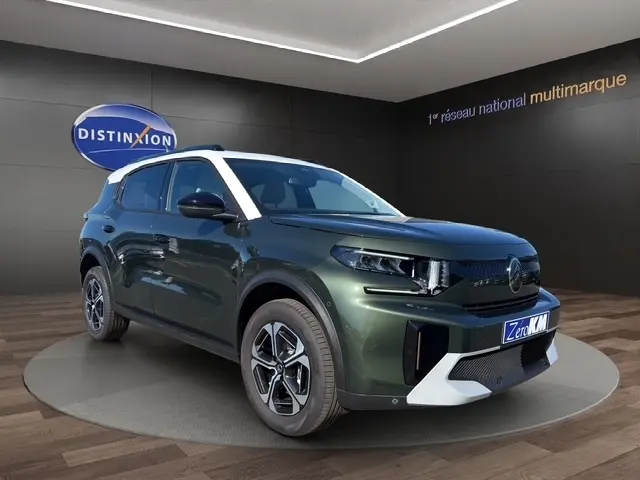 Citroën C3 Aircross hybride vert en 3/4 avant droit, avec toit blanc et jantes distinctives, en intérieur showroom.