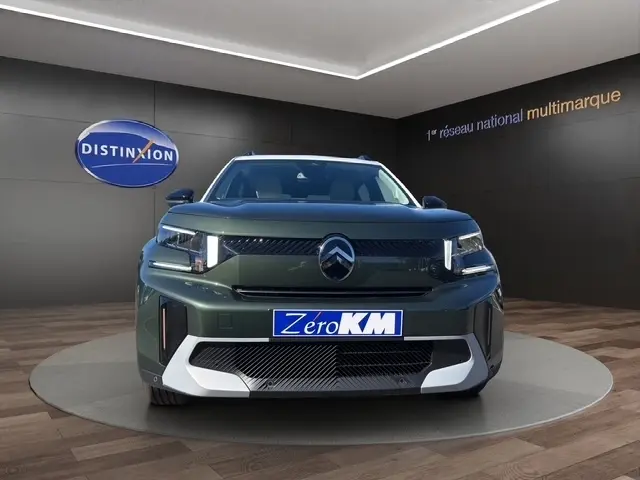 Vue avant d'une Citroën C3 Aircross hybride verte, avec calandre noire et détails argentés, en showroom.