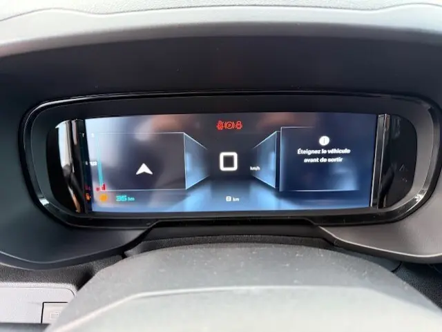 Tableau de bord numérique du Citroën Berlingo blanc 2026, affichant la vitesse à 0 km/h et un message d'alerte.
