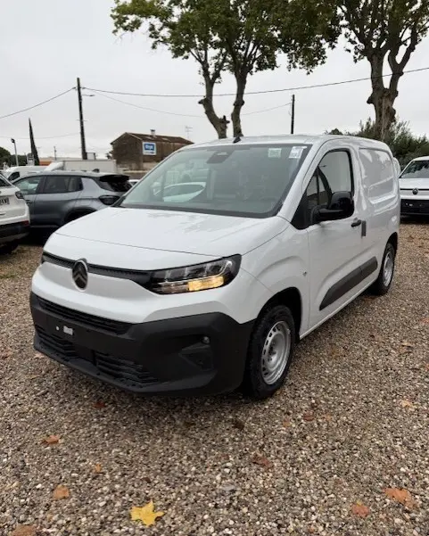 Citroën Berlingo Van Diesel blanc en 3/4 avant droit, avec calandre noire et feux allumés sur parking extérieur.