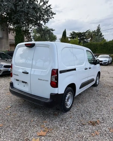 Vue 3/4 arrière droite d'un Citroën Berlingo blanc 2026 version van diesel, avec portes arrière pleines et protections latérales noires.