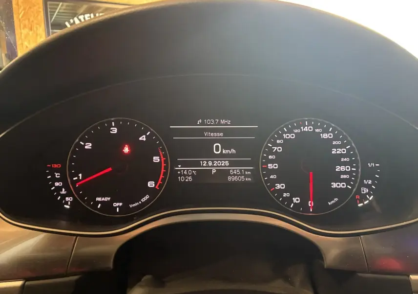 Vue rapprochée du tableau de bord numérique noir de l'Audi A6 Avant 2017, affichant vitesse zéro et compteurs éclairés.