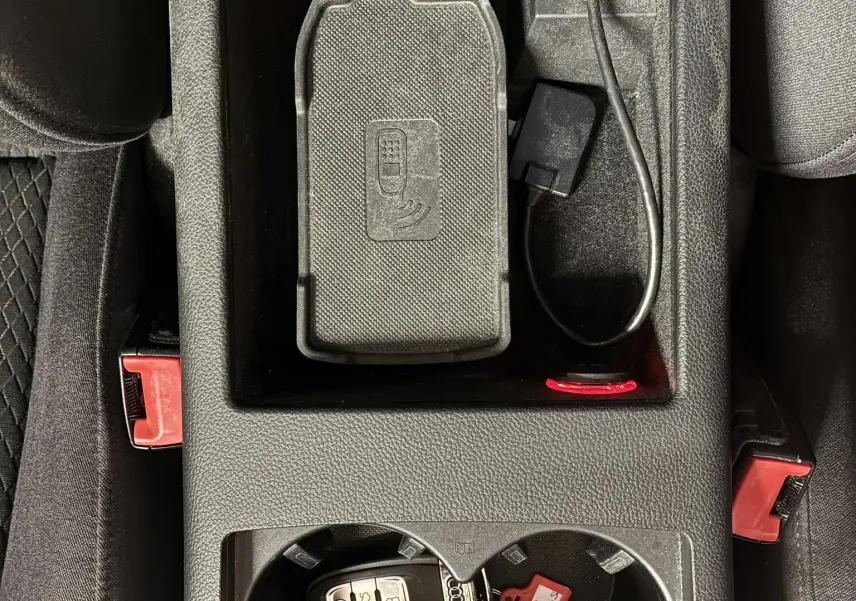 Vue plongeante sur la console centrale noire d'une Audi A6 Avant 2017 avec clé et accessoires de connexion.