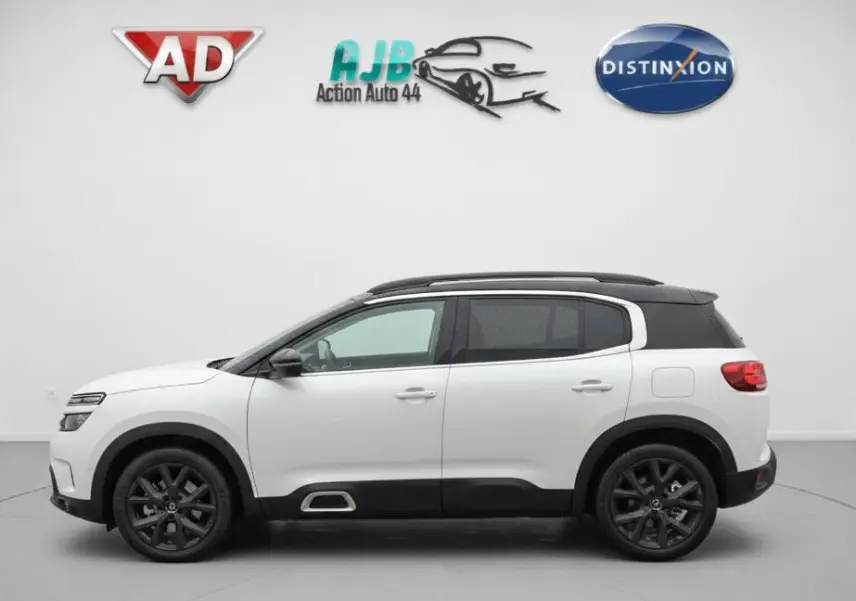 Vue de profil côté gauche du Citroën C5 Aircross blanc nacré avec toit noir et jantes noires en studio.