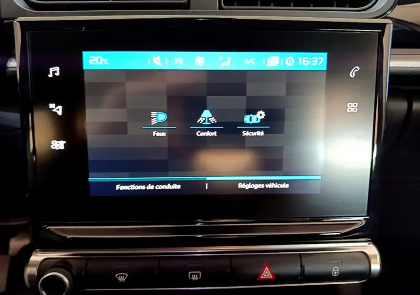 Écran tactile central affichant les réglages de conduite dans l'habitacle noir d'une Citroën C3 blanche de 2019.