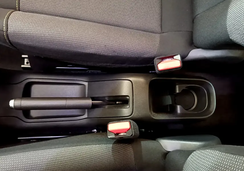 Vue plongeante sur la console centrale noire et les sièges tissu gris de la Citroën C3 blanche de 2019