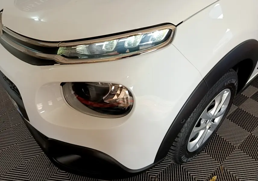 Gros plan sur l'avant droit blanc d'une Citroën C3 2019, mettant en valeur ses phares LED et la jante alliage.