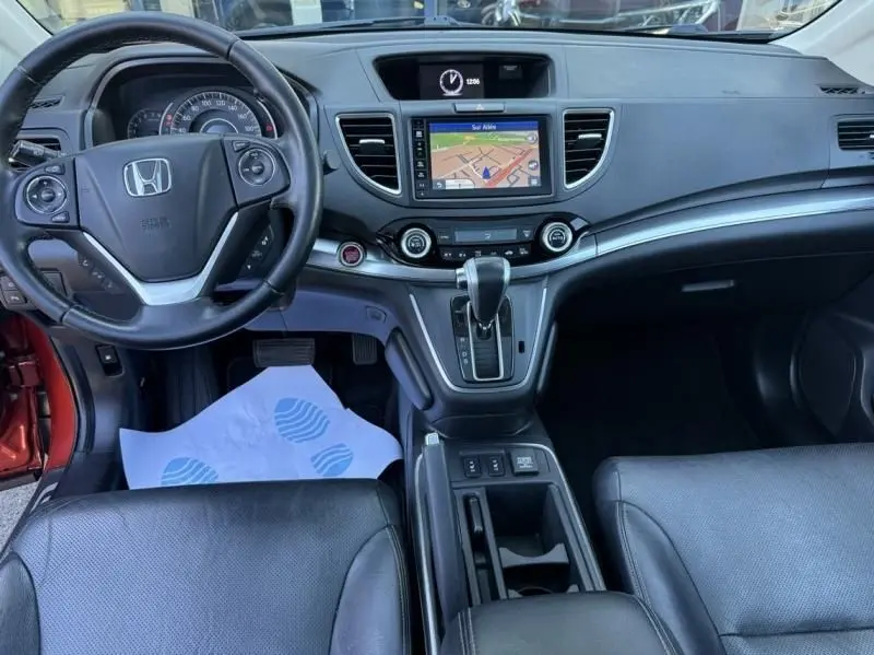 Vue intérieure du tableau de bord du Honda CR-V 2017 rouge métal, avec écran de navigation et boîte automatique.