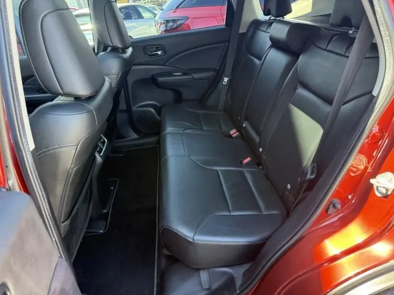 Vue intérieure côté droit sur la banquette arrière en cuir noir du Honda CR-V rouge métal 2017, porte ouverte.