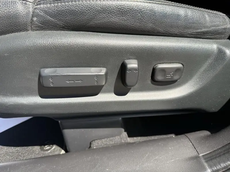 Gros plan sur les commandes de réglage électrique du siège conducteur en cuir noir du Honda CR-V rouge métal 2017.