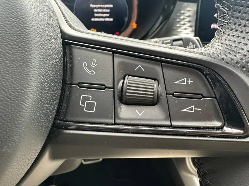 Gros plan sur les commandes multifonctions au volant cuir perforé de l'Alfa Romeo Tonale 1.5 Hybrid 2025.