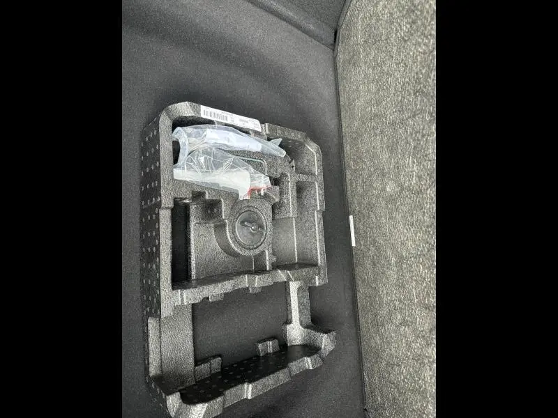 Coffrage en mousse noire avec outils de bord dans le coffre d'une Alfa Romeo Tonale blanc Monterosa Pastel.
