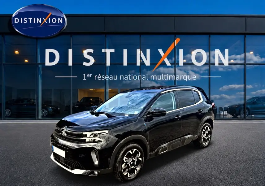 Citroën C5 Aircross noir en 3/4 avant droit, avec jantes alu distinctives et protections latérales grises.