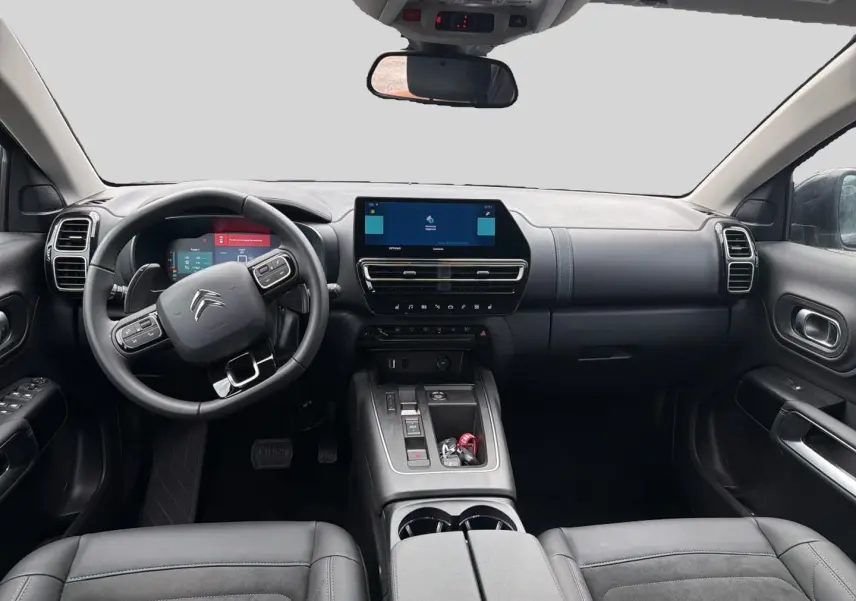 Vue intérieure avant du Citroën C5 Aircross 2024 noir, volant cuir multifonction et écran tactile central visible.