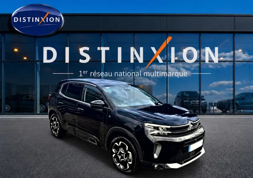 Citroën C5 Aircross noir vue 3/4 avant droit, avec jantes alu et calandre distinctive, devant un showroom Distinxion.