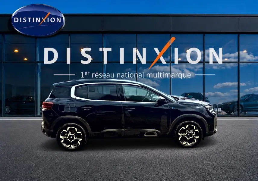 Profil côté gauche du Citroën C5 Aircross noir 2024 hybride rechargeable, avec jantes alu et barres de toit visibles.