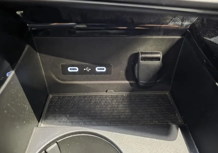 Gros plan sur la console centrale du Renault Austral 2024, montrant deux ports USB et une prise 12V dans un compartiment noir.