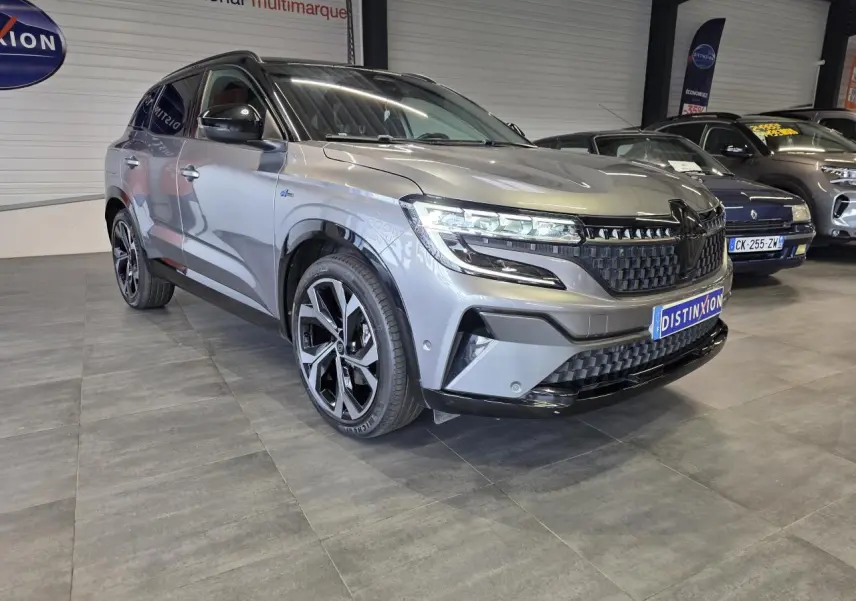 Renault Austral gris foncé en 3/4 avant droit, avec calandre damier ice black et jantes alliage 20 pouces.