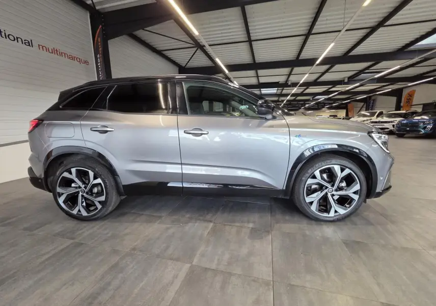 Profil droit du Renault Austral 2024 gris foncé avec toit noir étoilé et jantes alliage 20 pouces diamantées.
