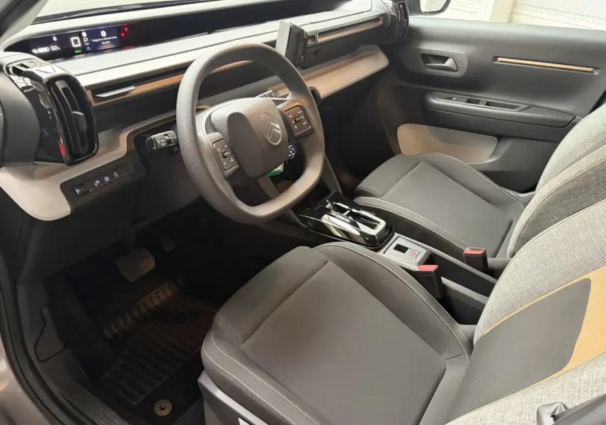 Intérieur avant droit du Citroën C3 Aircross électrique gris foncé, volant multifonctions et écran tactile visible.