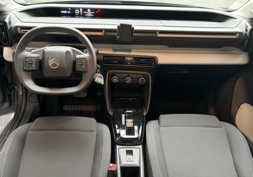 Vue intérieure frontale du tableau de bord et volant gris foncé du Citroën C3 Aircross électrique 2025.