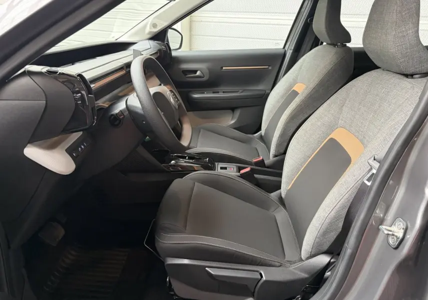 Vue intérieure côté conducteur de la Citroën C3 Aircross 2025 gris foncé, sièges tissu gris et noir avec détails beige.
