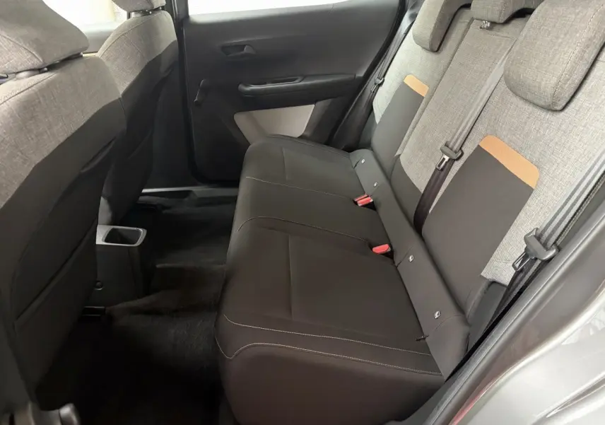 Vue intérieure côté droit des sièges arrière gris foncé et tissu clair avec détails orange de la Citroën C3 Aircross 2025 électrique.