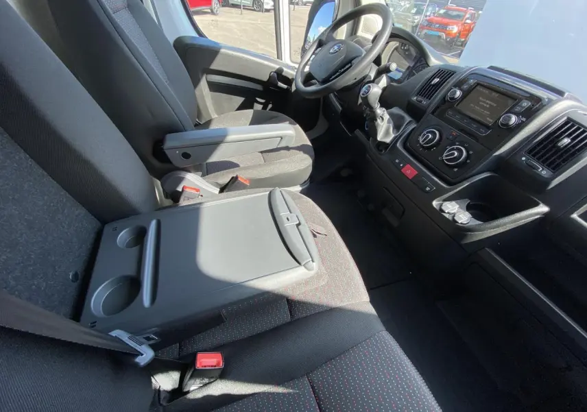 Intérieur avant de l'Opel Movano Fourgon blanc 2023, vue côté conducteur montrant sièges et tableau de bord.