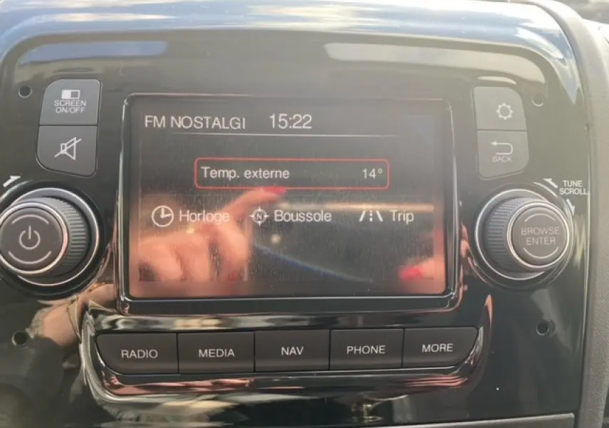 Écran tactile central du tableau de bord de l'Opel Movano Fourgon 2023 affichant la radio FM et la température externe.