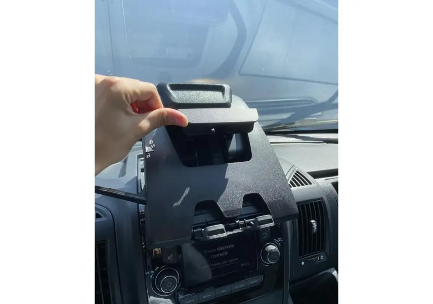Intérieur de l'Opel Movano Fourgon 2023 montrant le support téléphone au-dessus de la console centrale noire.