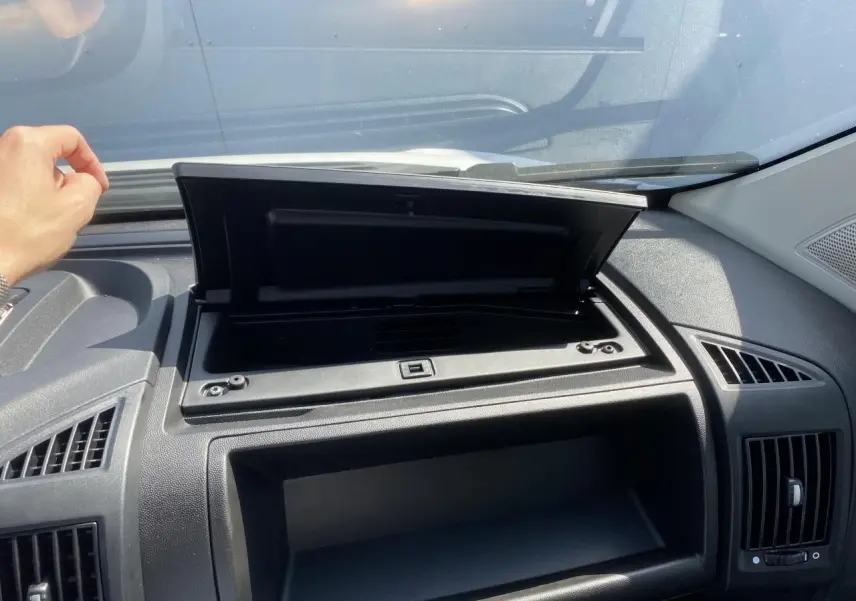 Intérieur du tableau de bord noir de l'Opel Movano Fourgon blanc 2023 avec boîte à gants ouverte côté passager.