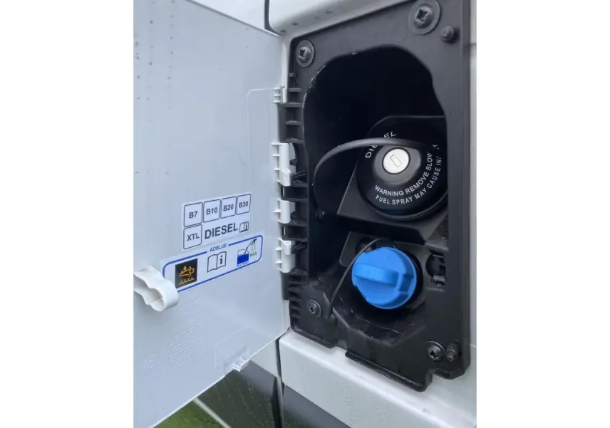 Gros plan sur la trappe à carburant blanche du fourgon Opel Movano Diesel, montrant bouchon noir diesel et bouchon bleu AdBlue.
