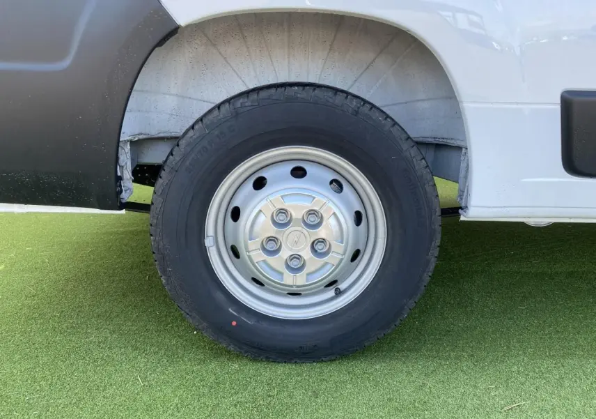 Gros plan sur la roue avant gauche en acier du fourgon blanc Opel Movano 2023, avec logo Opel au centre.