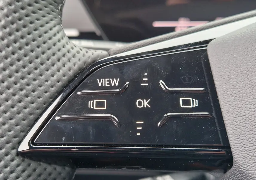 Gros plan sur les commandes tactiles noires du volant perforé de l'Audi Q6 e-tron Performance S-Line 2025.