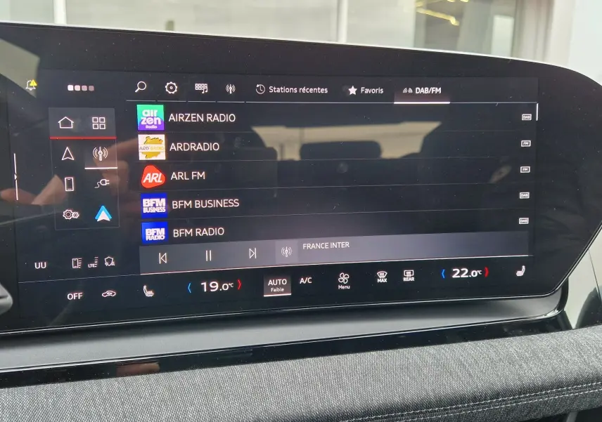 Écran tactile central de l'Audi Q6 e-tron Performance S-Line affichant les stations radio et commandes climatisation.