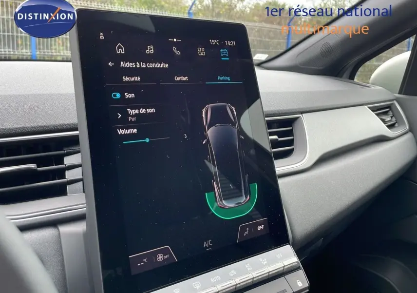 Écran tactile central affichant les aides à la conduite dans l'habitacle gris clair du Renault Captur E-Tech Hybrid 2025.