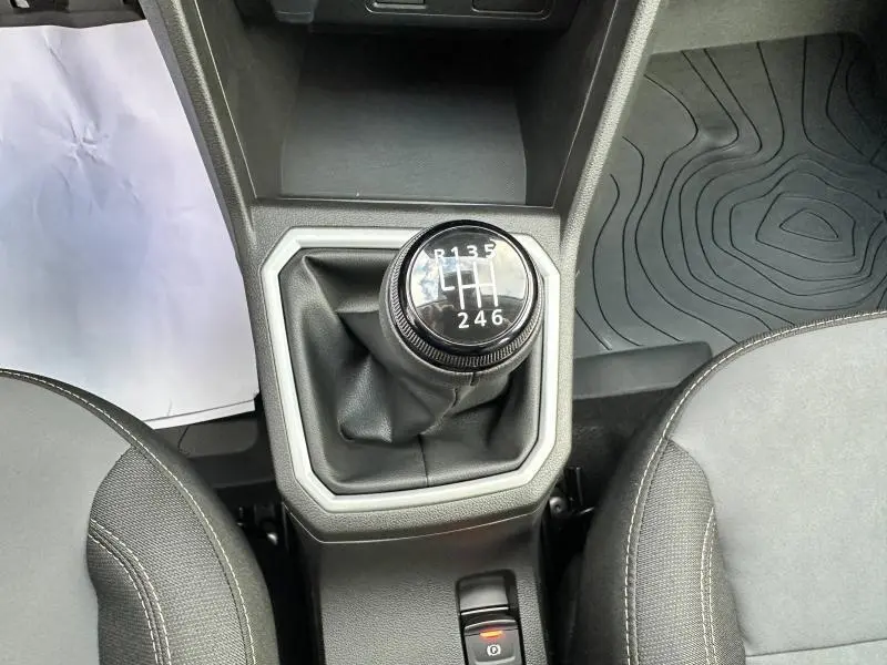 Le levier de vitesses manuel noir du Dacia Sandero Stepway 2025 en gris Schiste, vu de dessus entre les sièges avant.