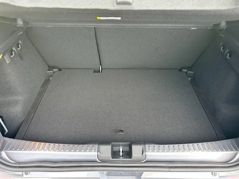 Coffre ouvert du Dacia Sandero Stepway 2025 gris schiste métallisé, montrant un espace de chargement propre et spacieux.