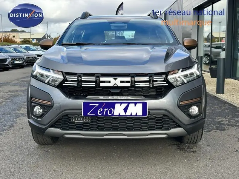 Vue frontale d'une Dacia Sandero Stepway 2025 gris schiste métallisé avec calandre noire et phares LED distinctifs.