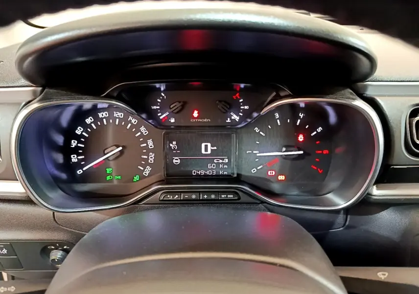 Tableau de bord de Citroën C3 blanc 2019 vu de face, affichage digital et compteurs analogiques éclairés.